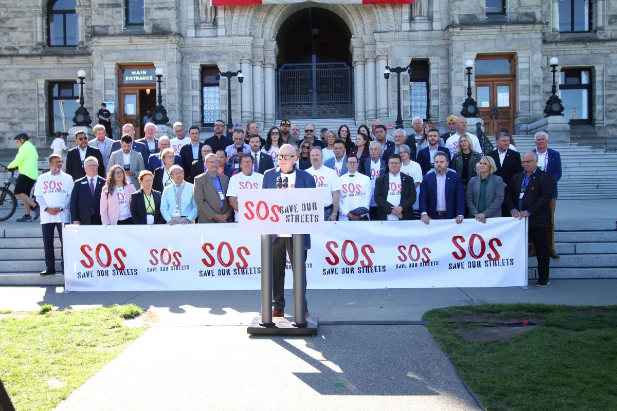 Mayors and councillors gathered on the BC Legislature steps behind a Save Our Streets banner
