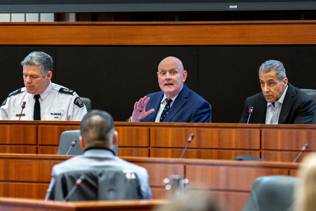 A panellist speaking between two others, one in uniform, at the Communities Driving Change Forum