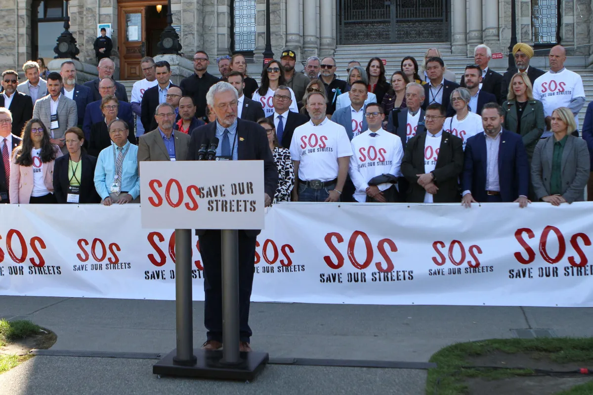 A speaker at a podium in front of rows of mayors and councillors at the BC Legislature